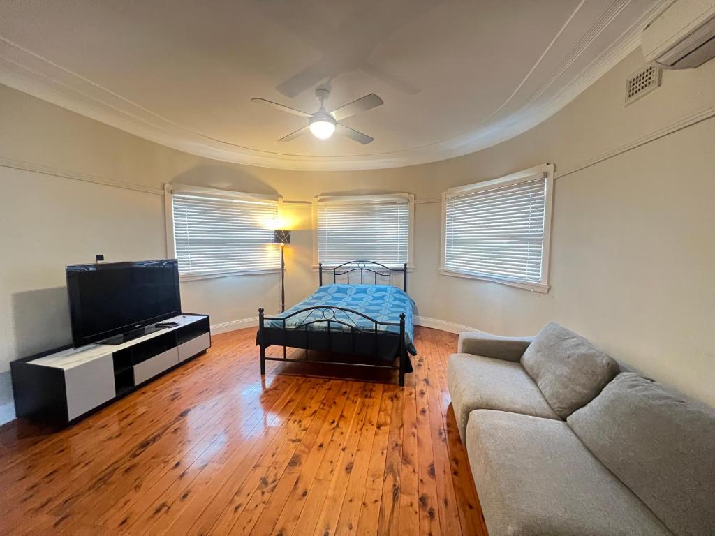 a living room with a couch and a flat screen tv at Room 78 in Merrylands