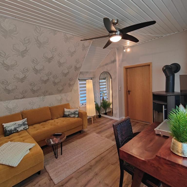 a living room with a couch and a ceiling fan at Altenauer Kaffee-Chalet in Altenau