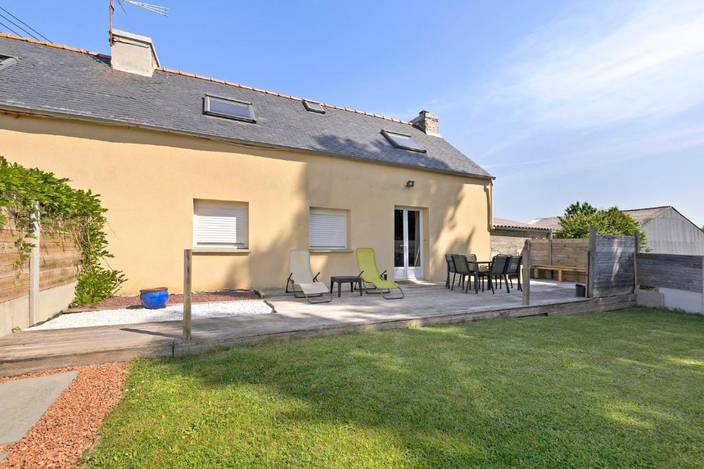 a patio with chairs and tables in a backyard at Gite cap 3KM plages in Telgruc-sur-Mer