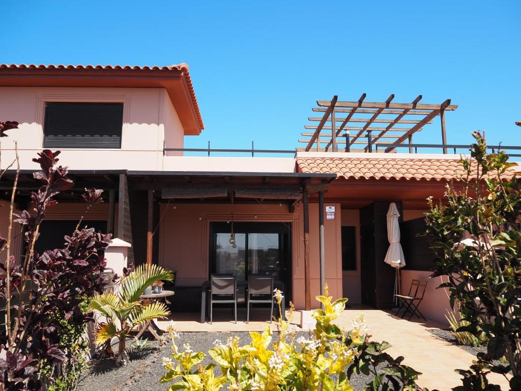 a house with a patio and a balcony on top at Fuerte Wave House in Lajares