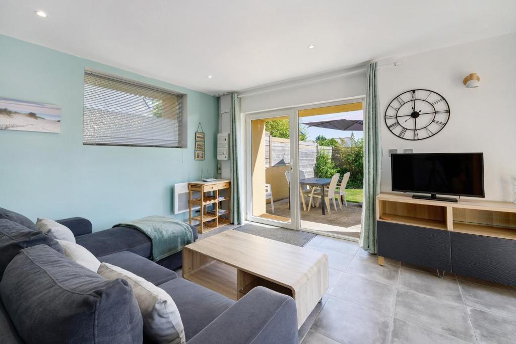 a living room with a couch and a tv and a table at Gite Dune 3km plage in Telgruc-sur-Mer