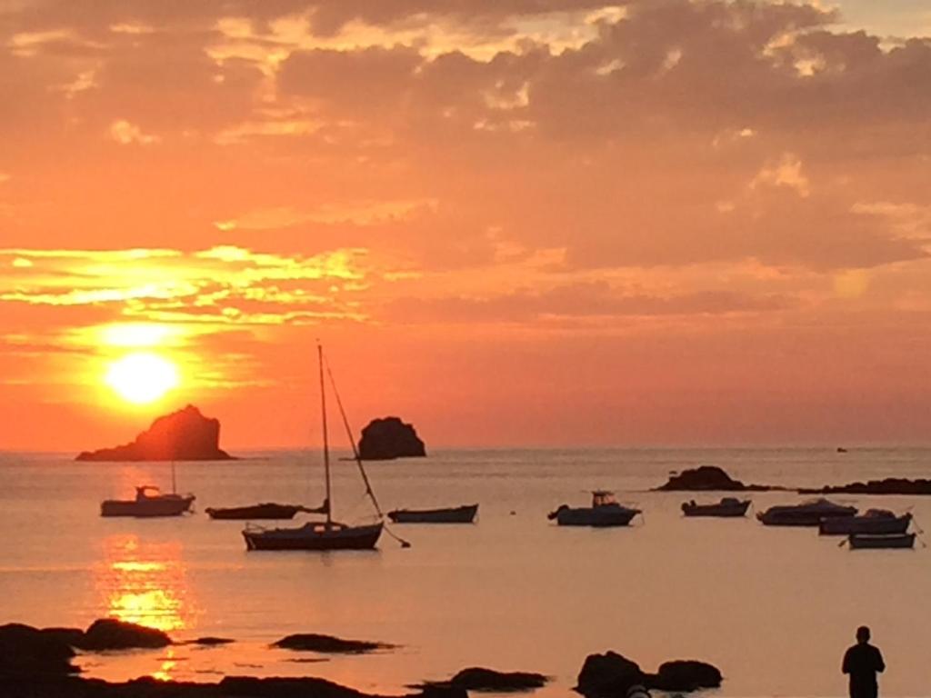 a sunset over the ocean with boats in the water at Idéalement placée in Santec