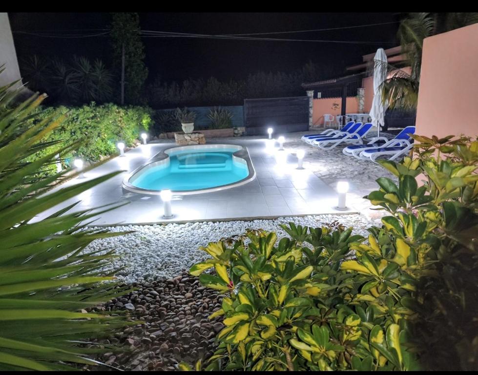 a backyard with a swimming pool at night at Villa Nuccia Oasi di relax con piscina in Castellammare del Golfo