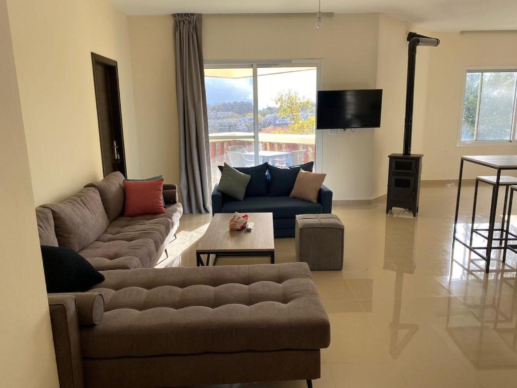 a living room with a couch and a table at Chalet 102 - Zresidence - Faitroun in Al ‘Aqabah
