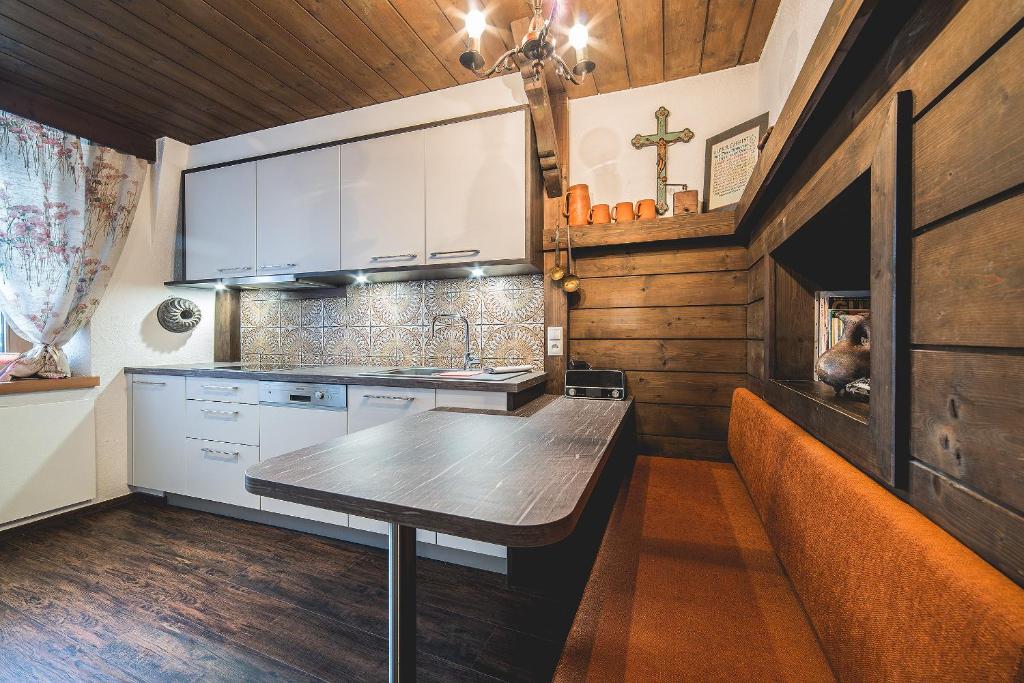 a kitchen with white cabinets and a wooden ceiling at Schneggnheisl - Appartement in Sautens