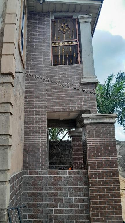 a clock on the side of a brick building at WF&DGS Care LODGE in Owerri