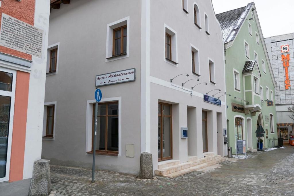 a white building with a sign on a street at Anitas Altstadtpension in Kelheim