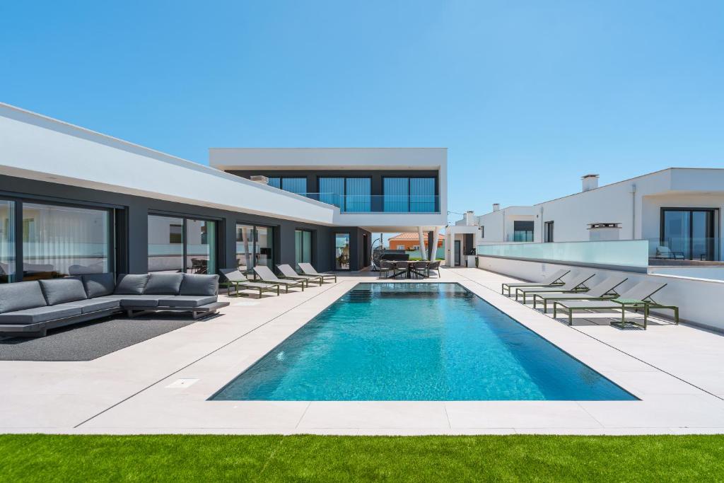 an exterior view of a house with a swimming pool at Casa Caracol, with a panoramic ocean view in Lourinhã