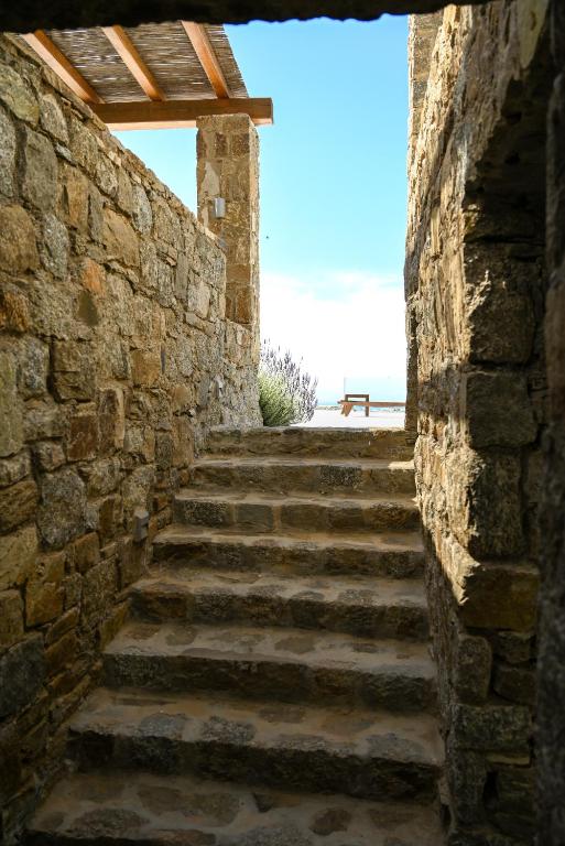 a stone stairway leading up to a stone wall at Nevo Mykonos in Mikonos