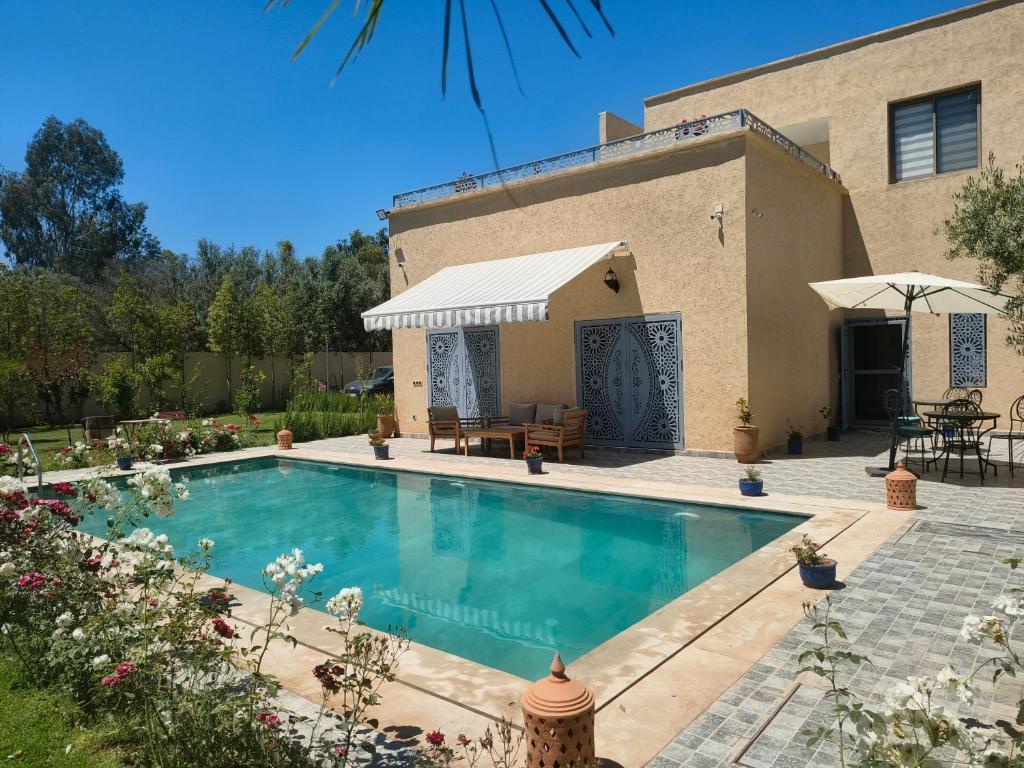 a swimming pool in front of a house at Dar Zaytouna in Oulad Akkou