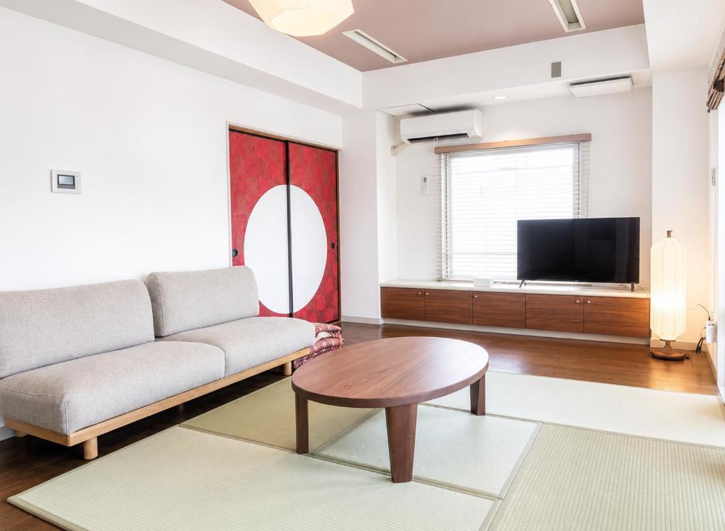 a living room with a couch and a table at The Little Kamakura Hotel 鎌倉駅徒歩2分 in Kamakura