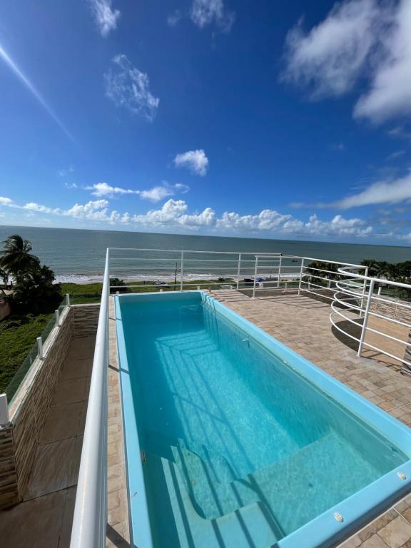 a swimming pool with a view of the ocean at Apartamento Frente Mar in Jacumã
