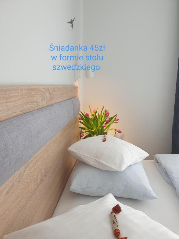 a bedroom with two pillows and a bed with a headboard at Pokoje Sandra I in Łeba