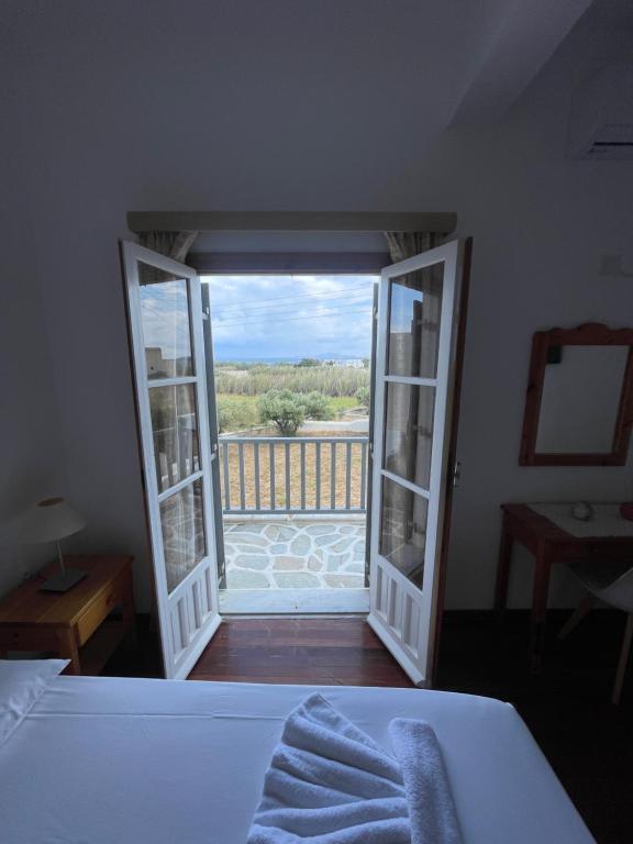 a bedroom with a bed and a view of a balcony at Paros Beach Studio Casa Costa Oro in Chrissi Akti