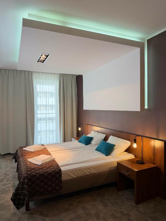 a bedroom with a large bed with a large window at Pokoje Hotel Diva 200 metrów do plaży in Kołobrzeg