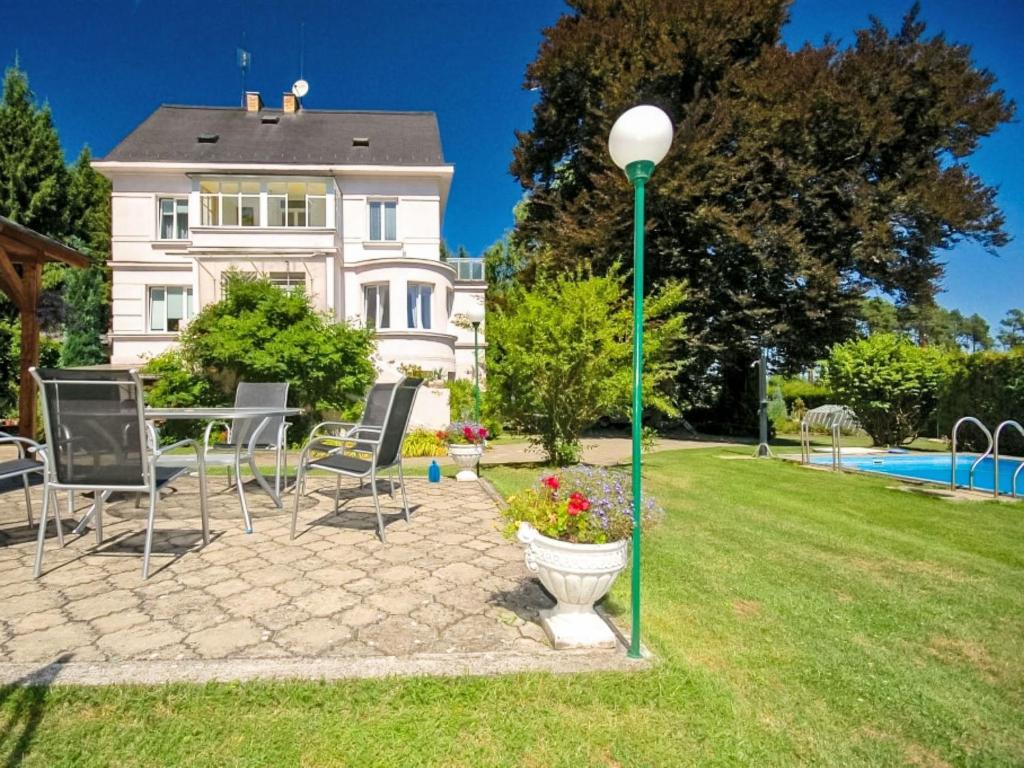a house with a yard with chairs and a light pole at Villa Forestside Villa by Interhome in Planá nad Lužnicí