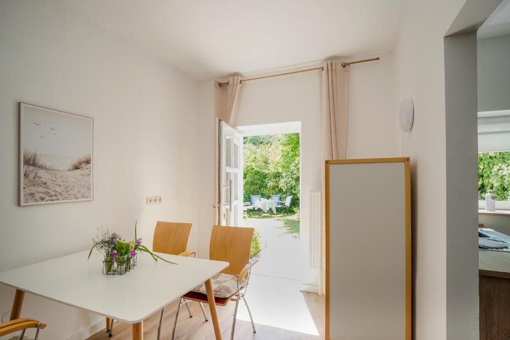 a kitchen and dining room with a white table and chairs at Ferienwohnung Seestern in zentraler Lage von Eckernförde in Eckernförde