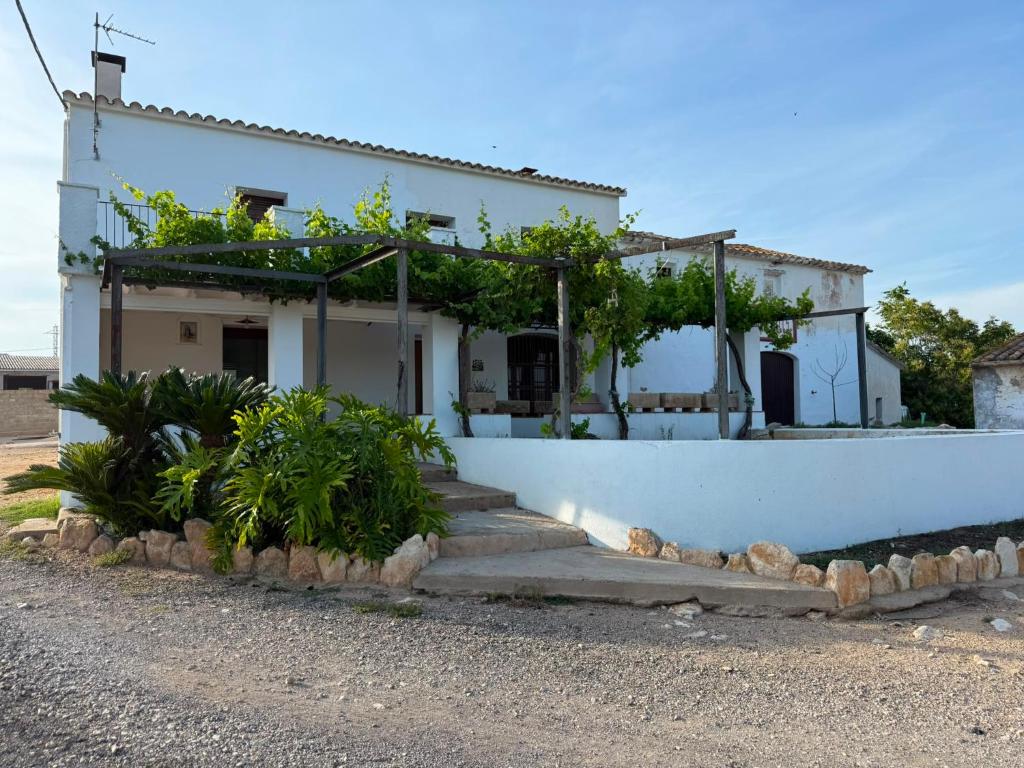 a white house with plants on the side of it at Masia Garridells in L'Ampolla