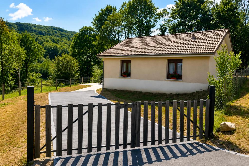 a gate in front of a small house at Charmante maison in Sussac