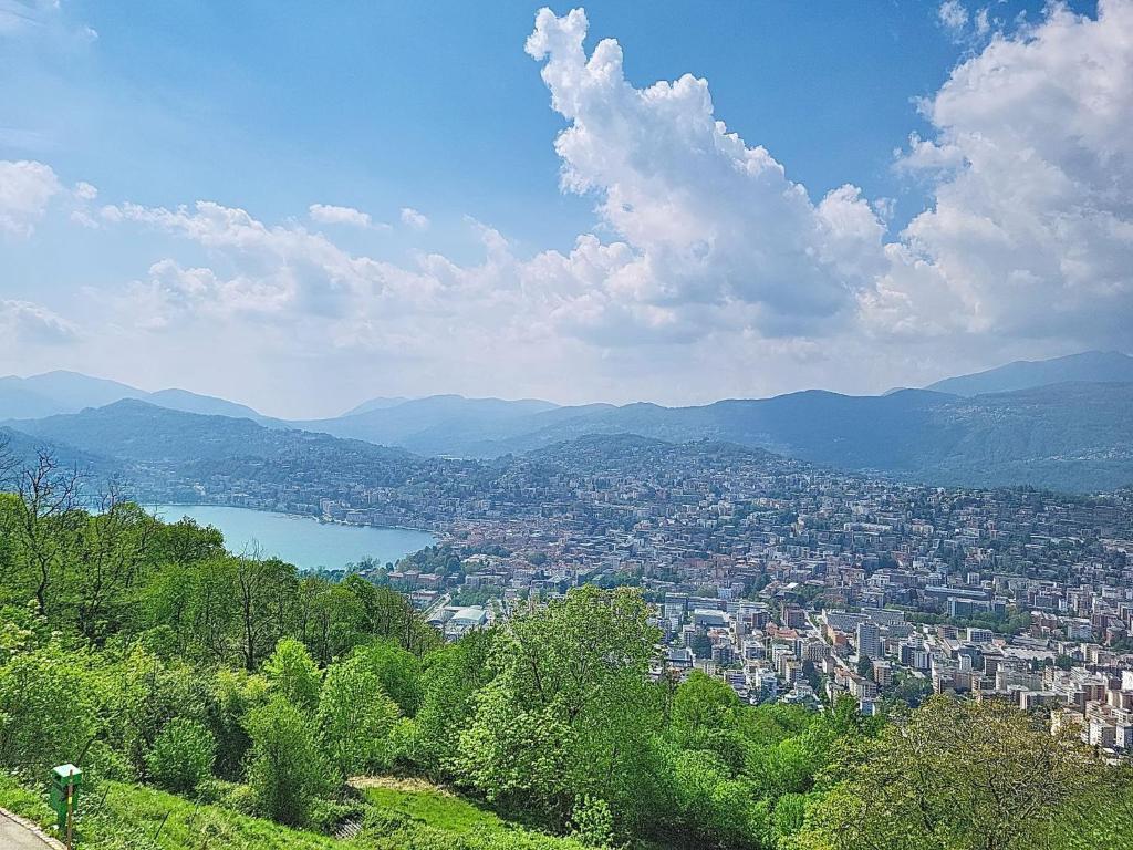 a view of a city with a lake and mountains at Apartment Apt-Woka by Interhome in Aldesago