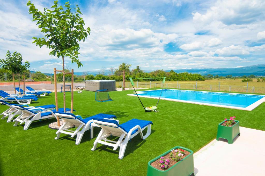 a group of chairs and a swimming pool at Vacation apartments Mario with salt water pool in Turjaci
