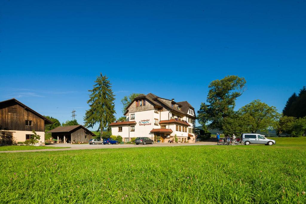 a large house with a green field in front of it at Landgasthof Kinzigstrand in Biberach bei Offenburg