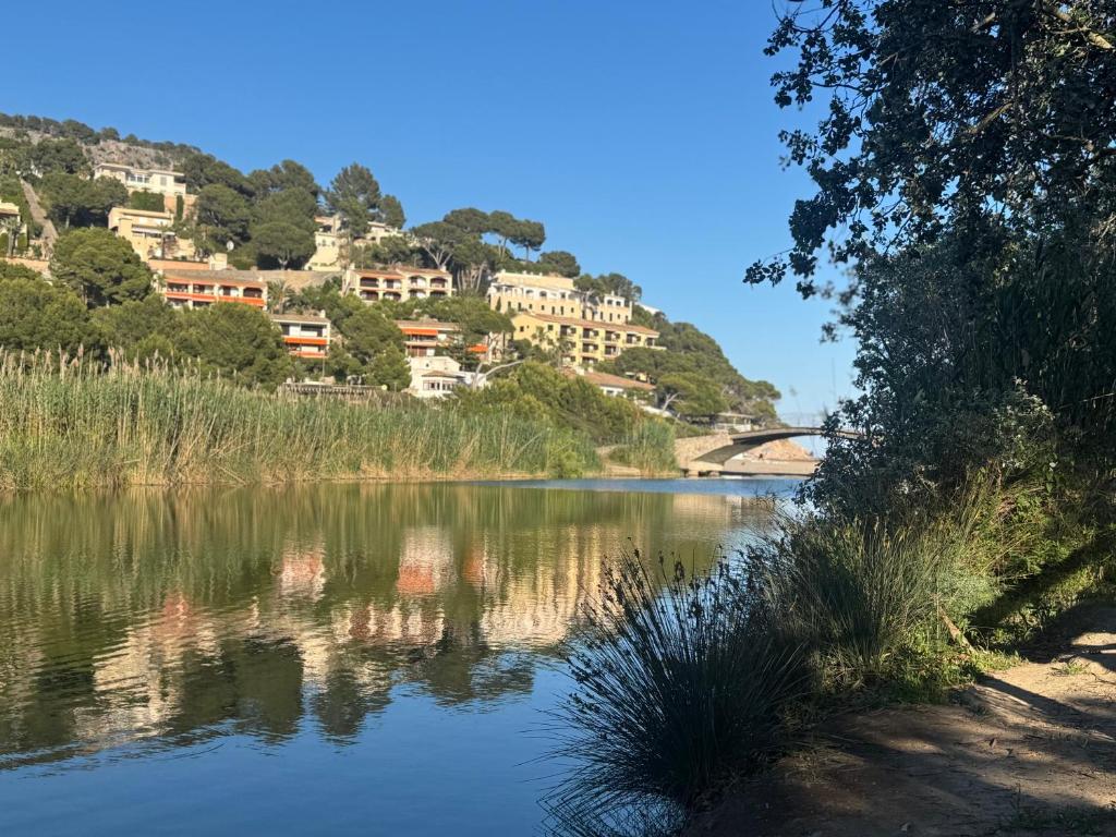 a view of a river with houses on a hill at Es Raco de Canyamel in Canyamel