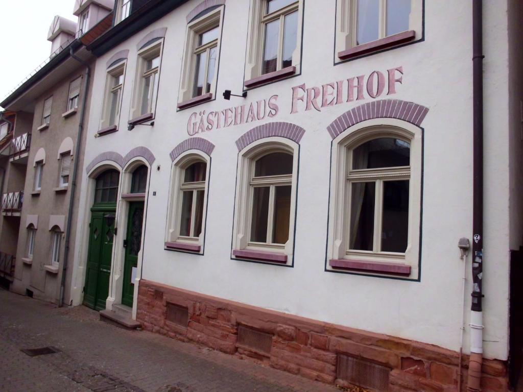 ein weißes Gebäude mit einem Schild an der Seite in der Unterkunft Hotel Freihof in Wiesloch