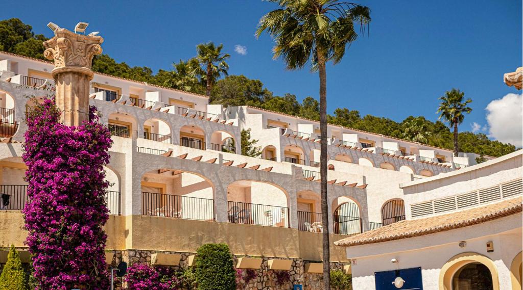 a large white building with flowers in front of it at Bungalows Imperial Park Unitursa in Calpe