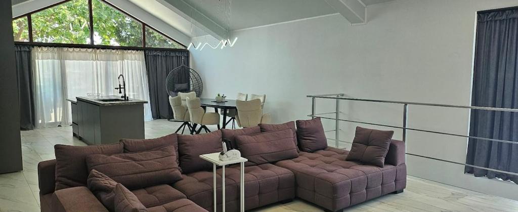 a living room with a brown couch and a table at ОмниЯ Терас in Chernomorets