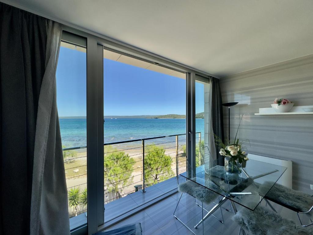 a room with a balcony with a view of the ocean at St.Barth Apartments in Šibenik