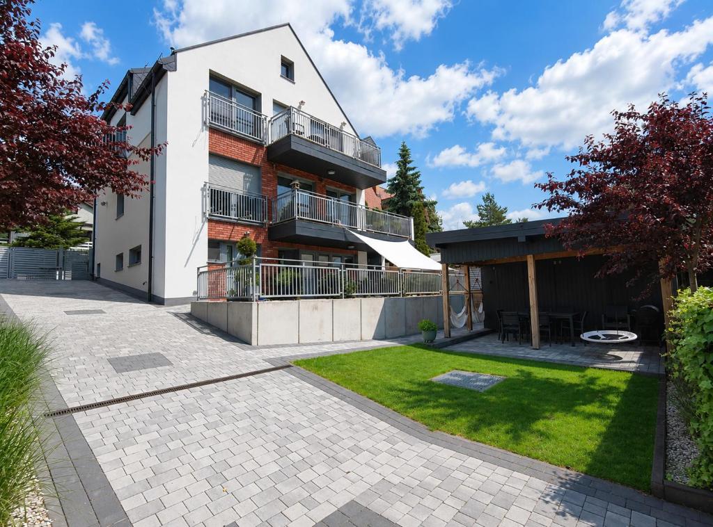 an apartment building with a patio and a yard at Willa na Orlej in Giewartów