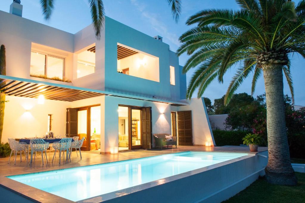 a villa with a swimming pool in front of a house at Casa Damienne in Porto Cristo