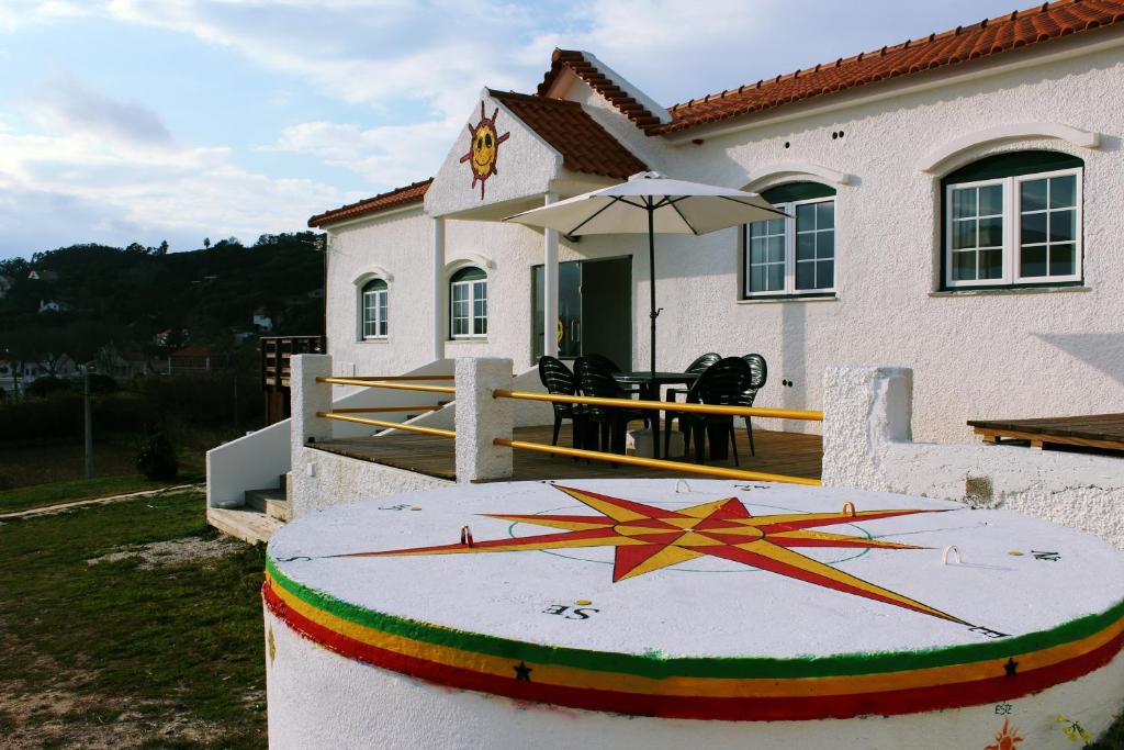 una casa con un reloj grande delante de ella en Sunshine Hostel en Foz do Arelho