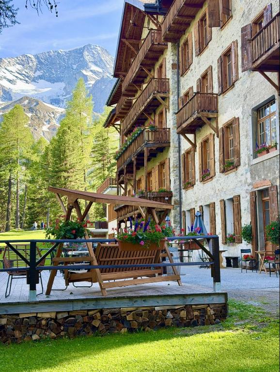 a wooden bench in front of a building at Grand Hôtel & Kurhaus in Arolla