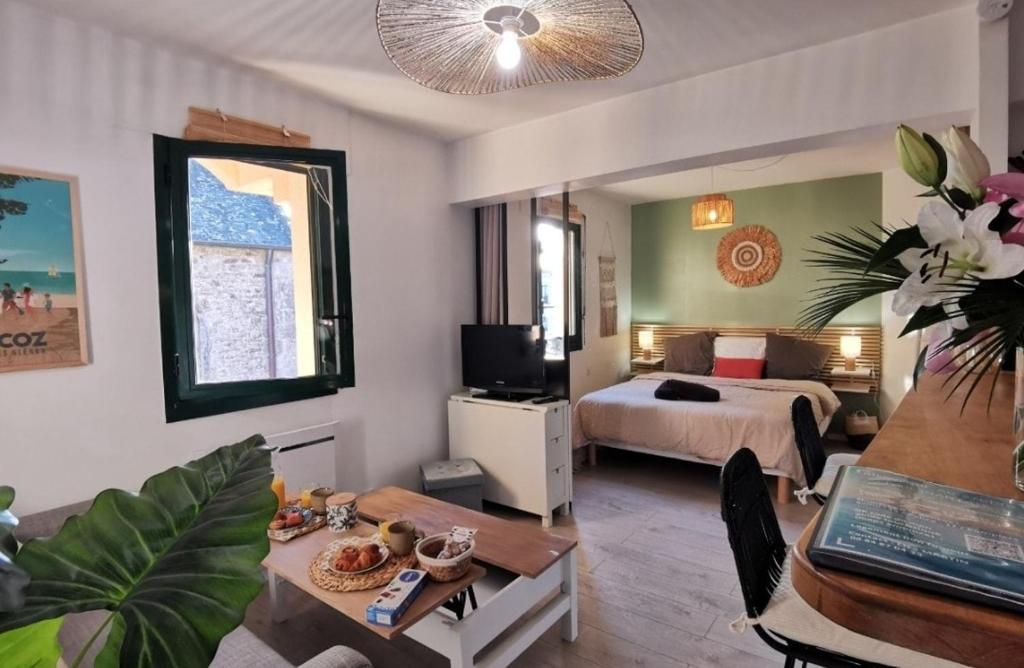 a hotel room with a bed and a table and a room at Le Studio Fouesnantais in Fouesnant