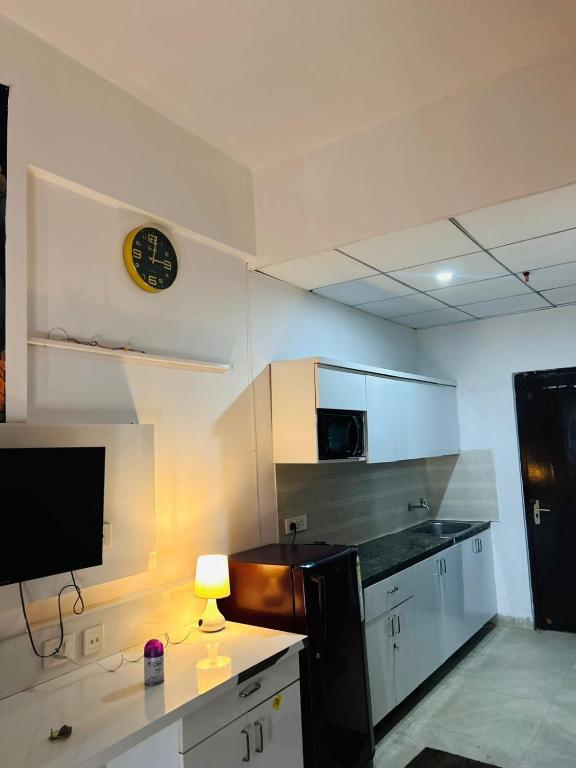 a kitchen with a counter and a clock on the wall at Zen Studio Paramount in Greater Noida
