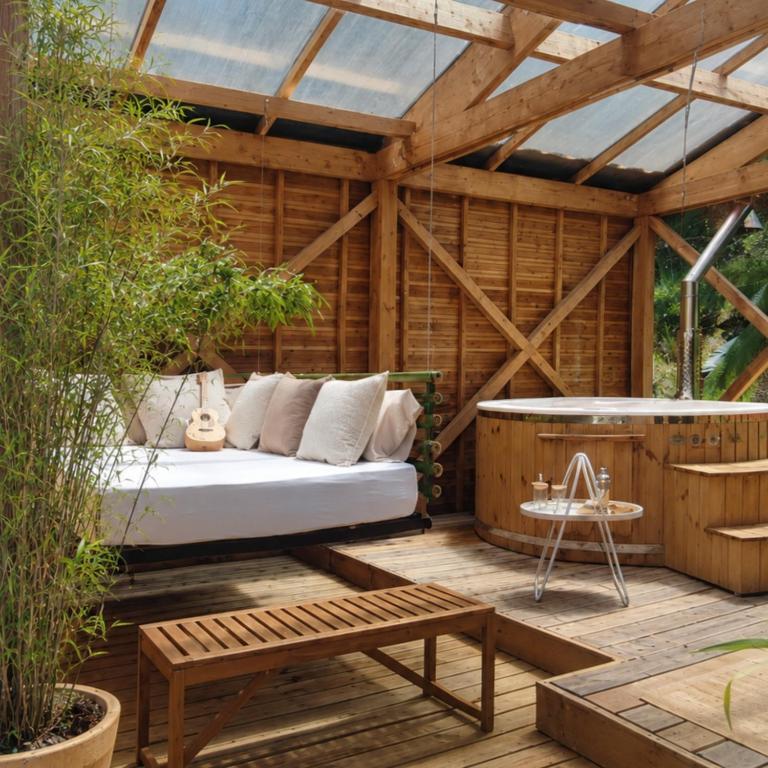 a wooden room with a bed and a hot tub at Les nids de Bonnan in Milhars