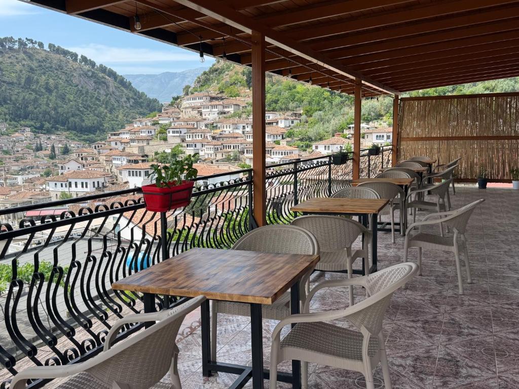 a row of tables and chairs on a balcony with a view at Guest House Eno in Berat