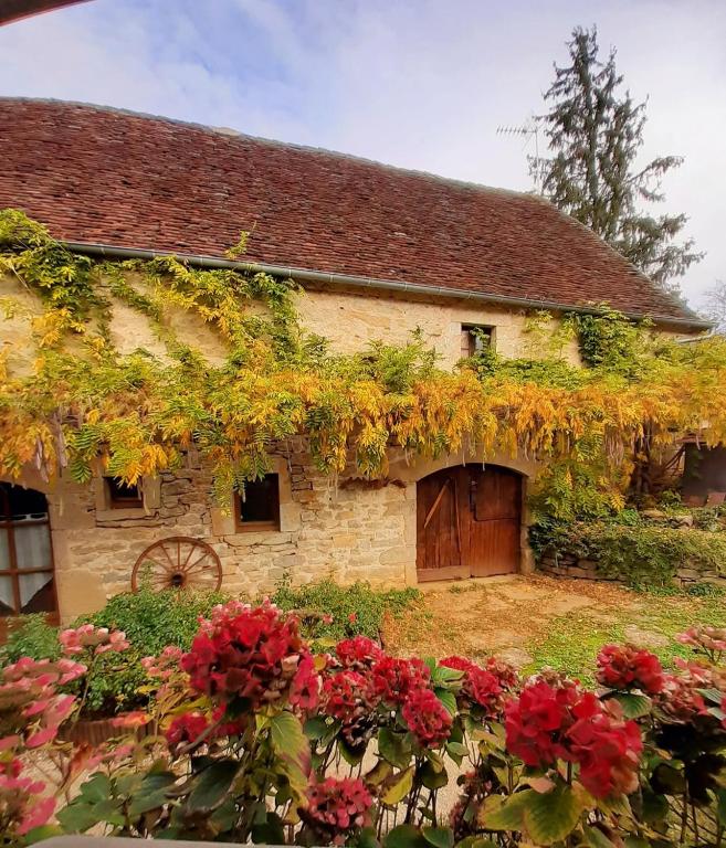 an old stone house with flowers in front of it at Gite Chez Santou in Rocamadour
