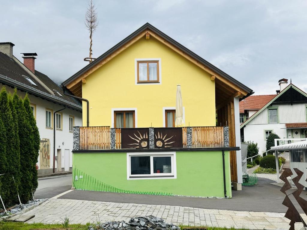 a yellow and green house with a balcony at Ferienhaus Ma-inz in Stadl an der Mur