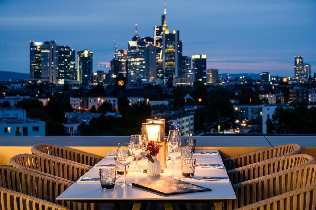 a table with wine glasses and a city skyline at The Blasky in Frankfurt
