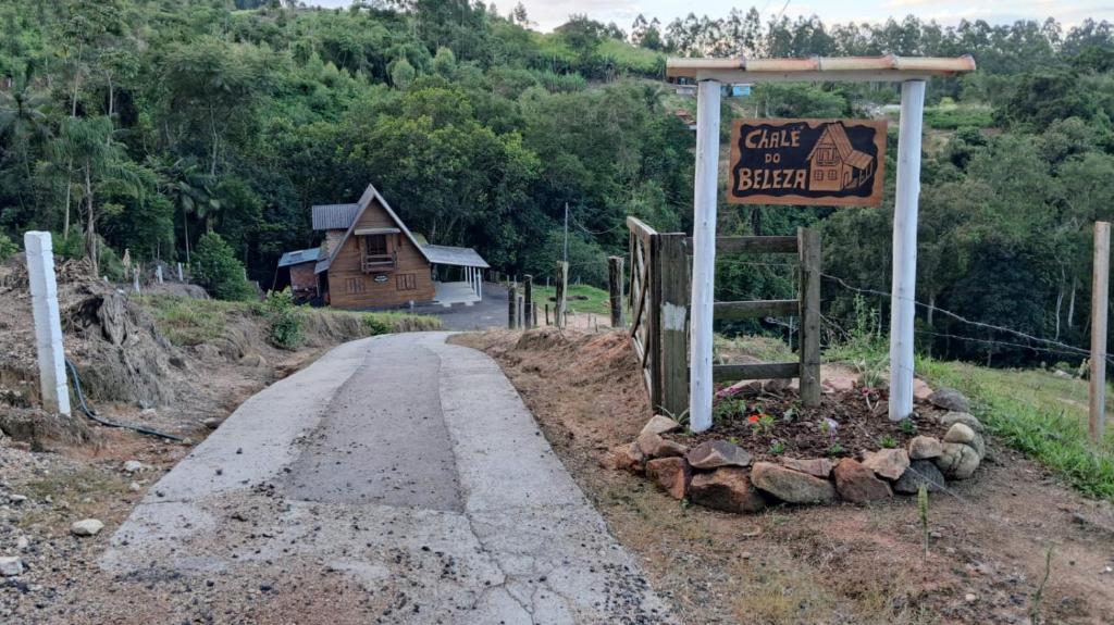 a sign for a car sit on the side of a road at Chalé do Beleza - Serra do Corvo in Braço do Norte