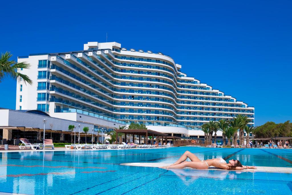 een vrouw op een zwembad voor een hotel bij Venosa Beach Resort & Spa - All Inclusive in Didim