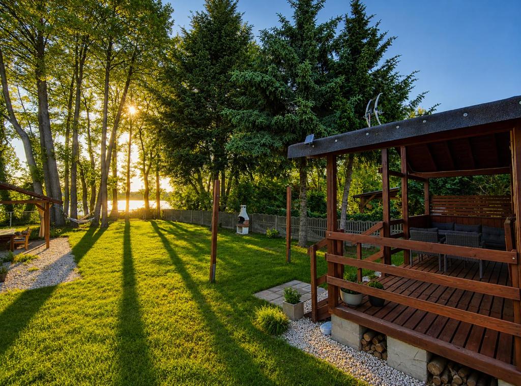 a backyard with a wooden pavilion and trees at Domek na Orlej in Giewartów