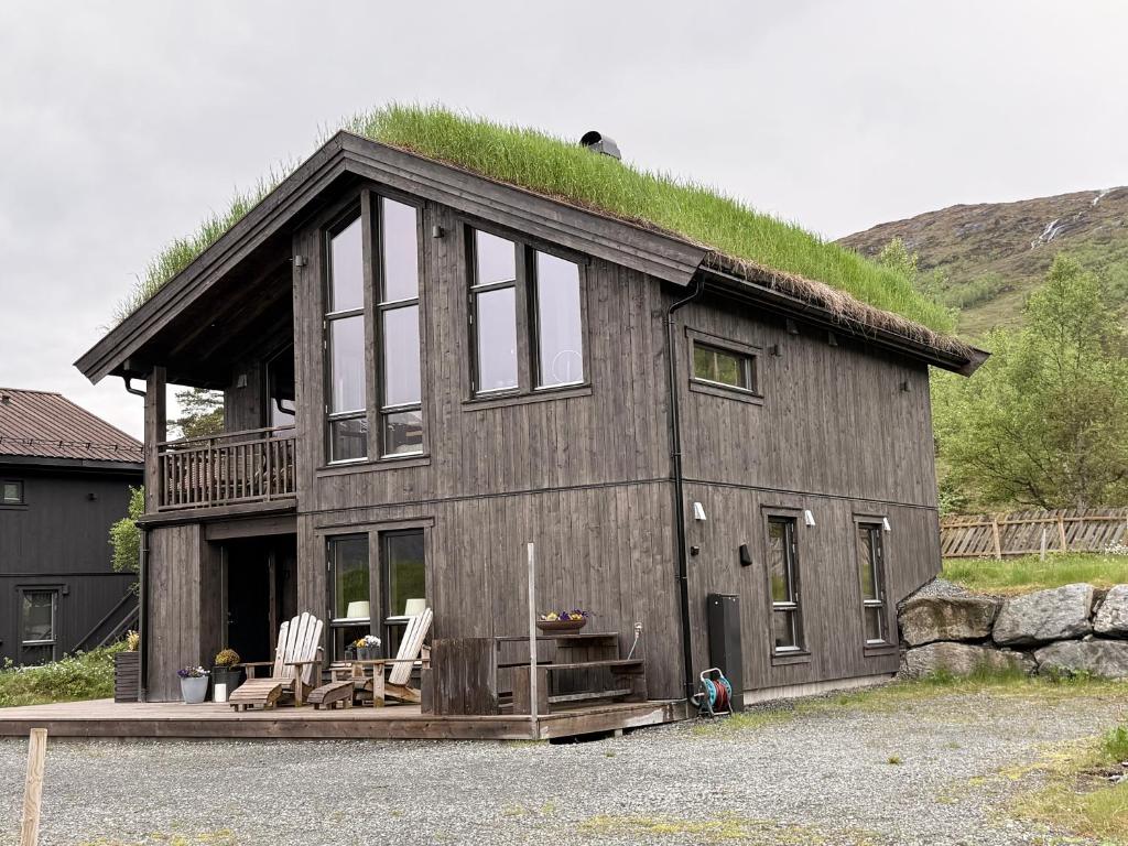 a house with a grass roof with two chairs at Harevadet 217 in Volda