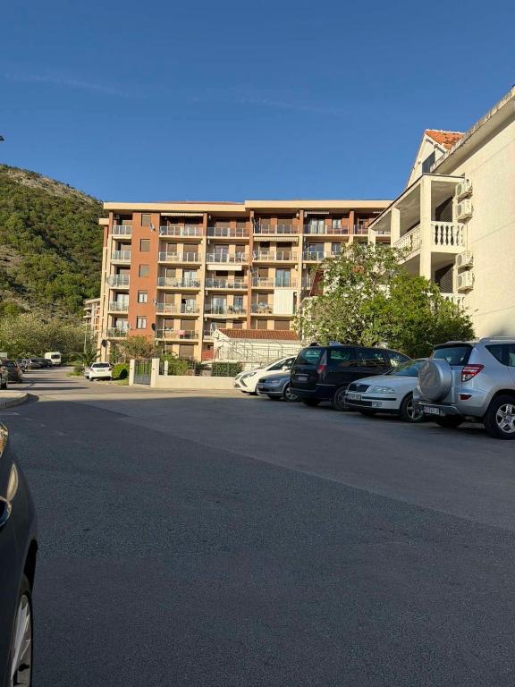 a parking lot with cars parked in front of a building at Apartman ML Company in Bečići