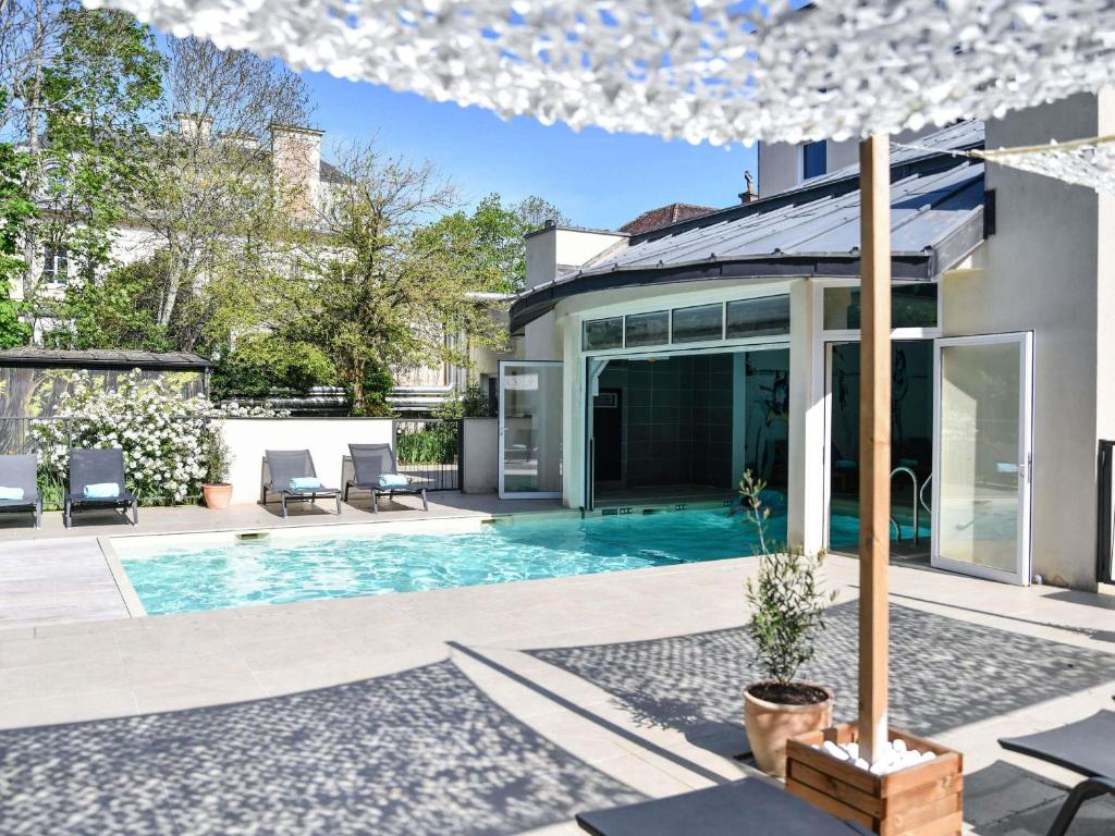 a swimming pool in the backyard of a house at Hotel Mercure Château de Fontainebleau in Fontainebleau
