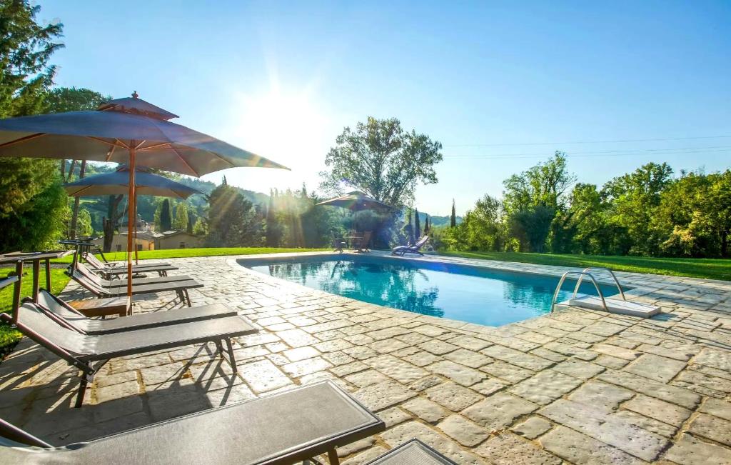 a swimming pool with two chairs and an umbrella at La Pimpinella di Semifonte in San Donnino