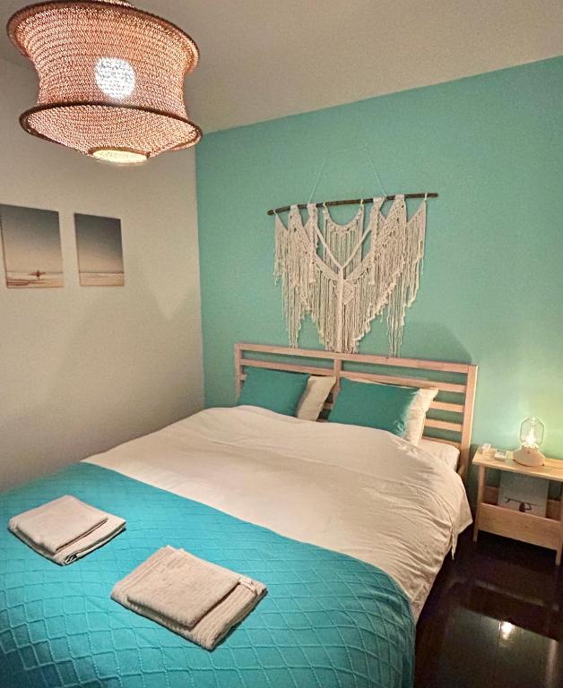 a blue bedroom with a bed with towels on it at MARSEA Resort in Zushi